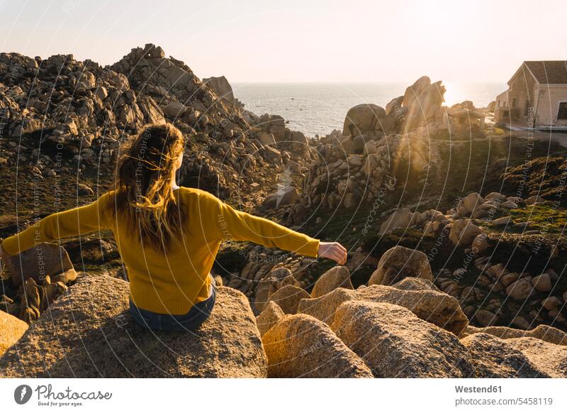 Italien, Sardinien, Frau auf einer Wanderung auf einem Felsen an der Küste sitzend Kueste Kuesten Küsten Wandertour weiblich Frauen sitzt wandern Ausflug