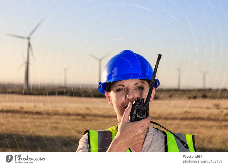 Weibliche Technikerin benutzt Walkie-Talkie in einem Windpark Technikerinnen Funksprechgerät Funksprechgeräte Handfunkgerät Walkie-Talkies Walkie Talkie