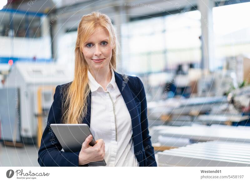 Porträt einer selbstbewussten Geschäftsfrau mit Tablet in einer Fabrik Fabriken Tablet Computer Tablet-PC Tablet PC iPad Tablet-Computer Portrait Porträts