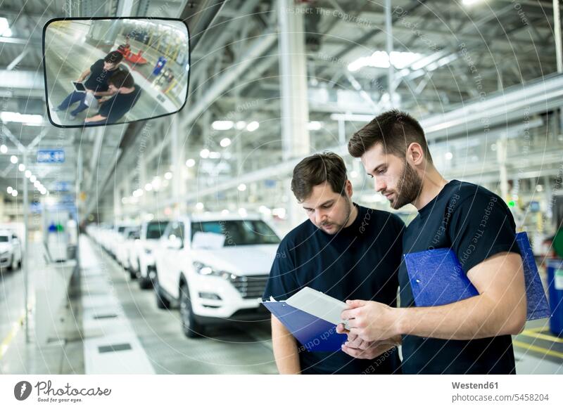 Zwei Kollegen arbeiten in einer modernen Autofabrik mit Zwischenablage und Tablett Arbeitskollege Arbeitskollegen Job Berufe Berufstätigkeit Beschäftigung Jobs