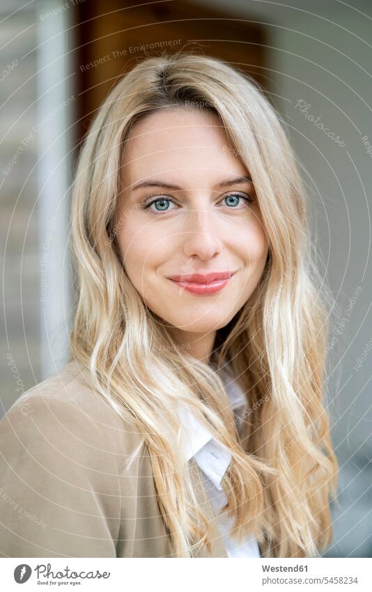 Nahaufnahme einer lächelnden Unternehmerin mit blonden Haaren im Büro Farbaufnahme Farbe Farbfoto Farbphoto Deutschland Millennials junge Erwachsene erwachsen
