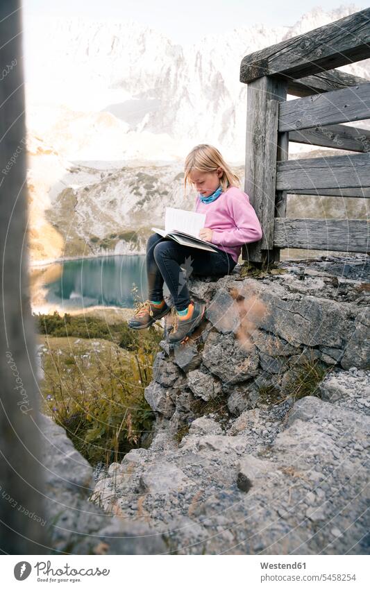 Österreich, Tirol, Mädchen liest Buch in Berglandschaft Berge weiblich lesen Lektüre Bücher Berglandschaften Landschaft Landschaften Kind Kinder Kids Mensch