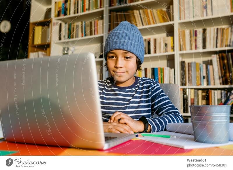 Junge, der den Hausunterricht über Laptop am Tisch im Wohnzimmer besucht Farbaufnahme Farbe Farbfoto Farbphoto 10-11 Jahre 10 bis 11 Jahre 10 - 11 Jahre Kinder