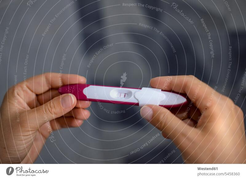Nahaufnahme der Hände einer Frau, die einen positiven Schwangerschaftstest hält halten weiblich Frauen Hand Schwangerschaftstests Test testen überprüfen