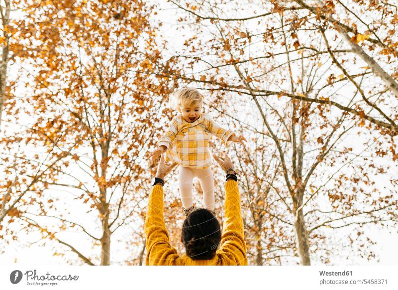 Vater wirft seine Tochter in die Luft, in einem Park im Herbst Vertrauen vertrauen Parkanlagen Parks herbstlich Papas Väter Vati Vatis Papis Töchter werfen Wurf