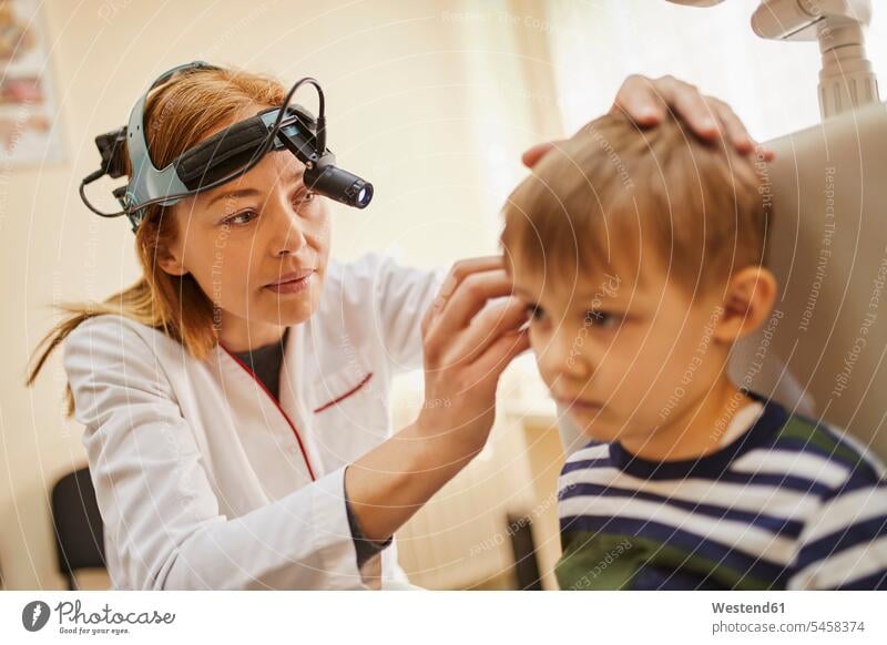 HNO-Arzt untersucht Ohr eines Jungen Ärztin Aerztin Ärztinnen Doktorinnen Aerztinnen untersuchen prüfen Ohren Buben Knabe Knaben männlich Doktoren Ärzte Medizin