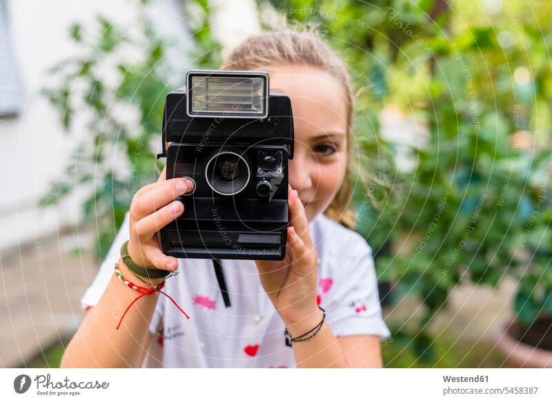 Mädchen, das mit einer altmodischen Kamera im Freien fotografiert Fotokamera Kameras freuen Muße Spass spassig spaßig Spässe Späße außen draußen frontal