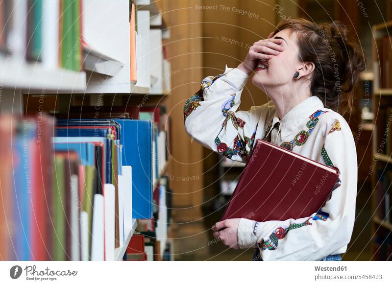 Studentin beim Lesen eines Buches in einer öffentlichen Bibliothek Bücher Frau weiblich Frauen Leseratte Bücherwurm Studentinnen Hochschülerin Hochschülerinnen