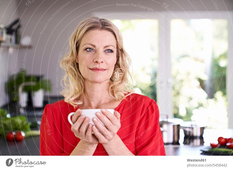 Porträt einer Frau beim Kaffeetrinken in der Küche Portrait Porträts Portraits weiblich Frauen Küchen Getränk Getraenk Getränke Getraenke Food and Drink