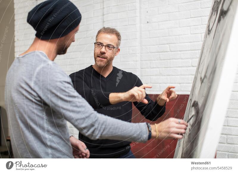 Künstler bespricht Zeichnung mit Mann im Atelier Studio Studios Ateliers besprechen diskutieren Besprechung Zeichnungen Männer männlich Bild Bildnis Bilder