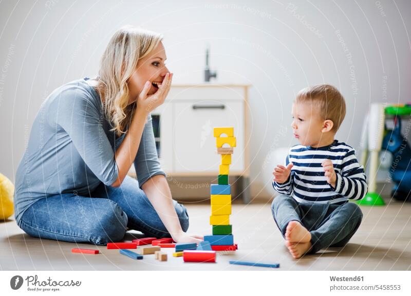 Glückliche Mutter und Kleinkind Sohn spielen mit Bausteinen zu Hause Bauklotz Zuhause daheim glücklich glücklich sein glücklichsein Söhne Mami Mutti Mütter Mama