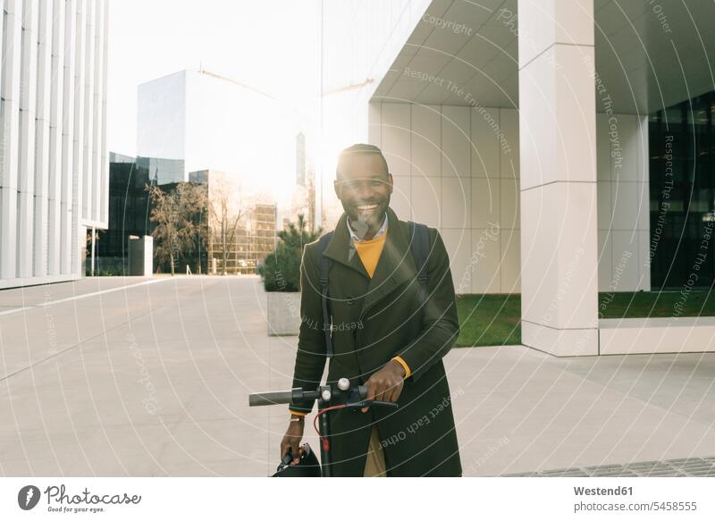 Porträt eines glücklichen Mannes mit Roller in der Stadt Leute Menschen People Person Personen Afrikanisch Afrikanische Abstammung dunkelhäutig Farbige Farbiger