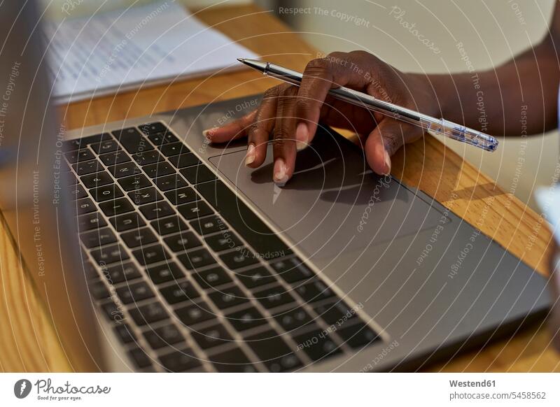 Abgehackte Hand einer Frau, die beim Lernen zu Hause einen Laptop auf dem Tisch benutzt Farbaufnahme Farbe Farbfoto Farbphoto Mosambik Republik Mosambik Afrika