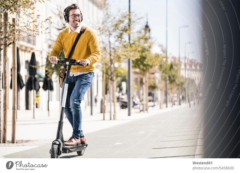 Junger Mann fährt E-Scooter in der Stadt Touristen geschäftlich Geschäftsleben Geschäftswelt Geschäftsperson Geschäftspersonen Businessmann Businessmänner