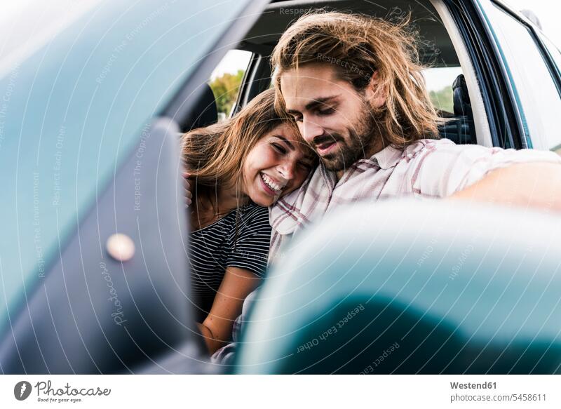 Glückliches junges Paar in einem Auto Pärchen Paare Partnerschaft Wagen PKWs Automobil Autos Zuneigung glücklich glücklich sein glücklichsein Mensch Menschen