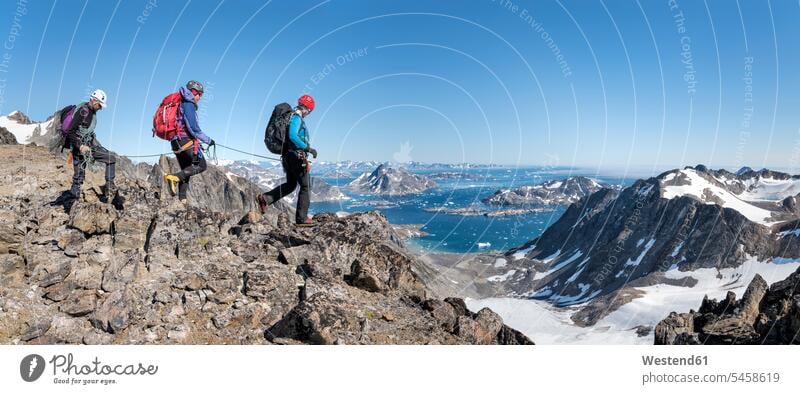 Grönland, Sermersooq, Kulusuk, Schweizer Alpen, Bergsteiger beim Wandern in felsiger Berglandschaft steinig verschneit schneebedeckt Berglandschaften gehen