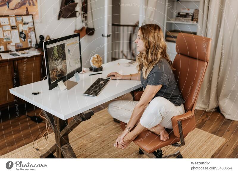Frau benutzt Computer zu Hause am Schreibtisch Farbaufnahme Farbe Farbfoto Farbphoto Freizeitkleidung Freizeitbekleidung casual Innenaufnahme Innenaufnahmen