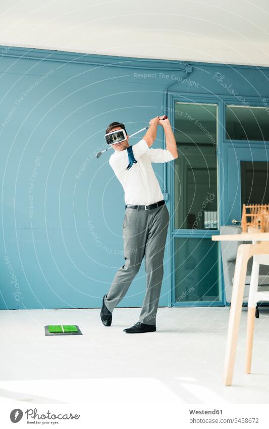 Geschäftsmann mit VR-Brille spielt Golf im Büro Virtual Reality Virtuelle Realität Businessmann Businessmänner Geschäftsmänner spielen Brillen golfend Golfsport