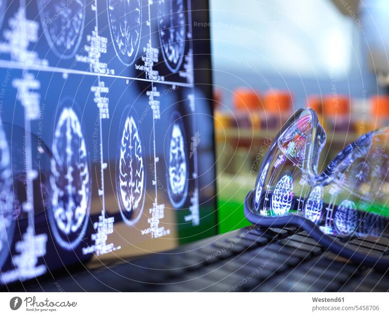 Gehirn-Scan-Ergebnisse, die in einer auf der Laptop-Tastatur liegenden Schutzbrille reflektiert werden Außenaufnahme außen draußen im Freien Tag
