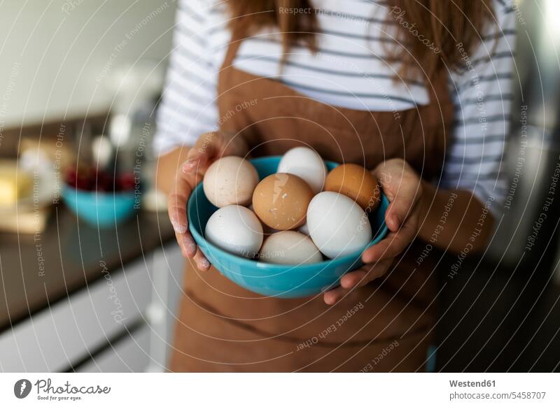 Nahaufnahme einer jungen Frau, die zu Hause in der Küche Eier hält Farbaufnahme Farbe Farbfoto Farbphoto Spanien Innenaufnahme Innenaufnahmen innen drinnen