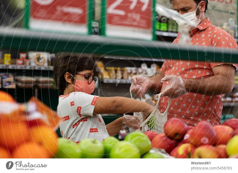 Vater und Sohn mit Masken im Supermarkt Taschen Einkaufstaschen Handschuhe T-Shirts Brillen Kauf Einkaufen shoppen shopping geschützt schützen Absicherung