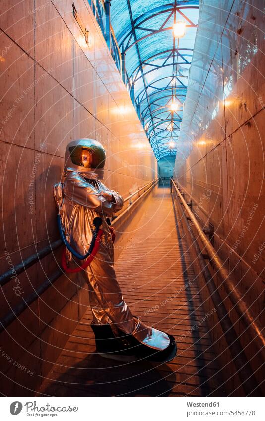 Raumfahrer in der Stadt bei Nacht stehend in einem engen Durchgang Weltraumfahrer Gang Astronaut Astronauten staedtisch städtisch steht schmal nachts Raumfahrt