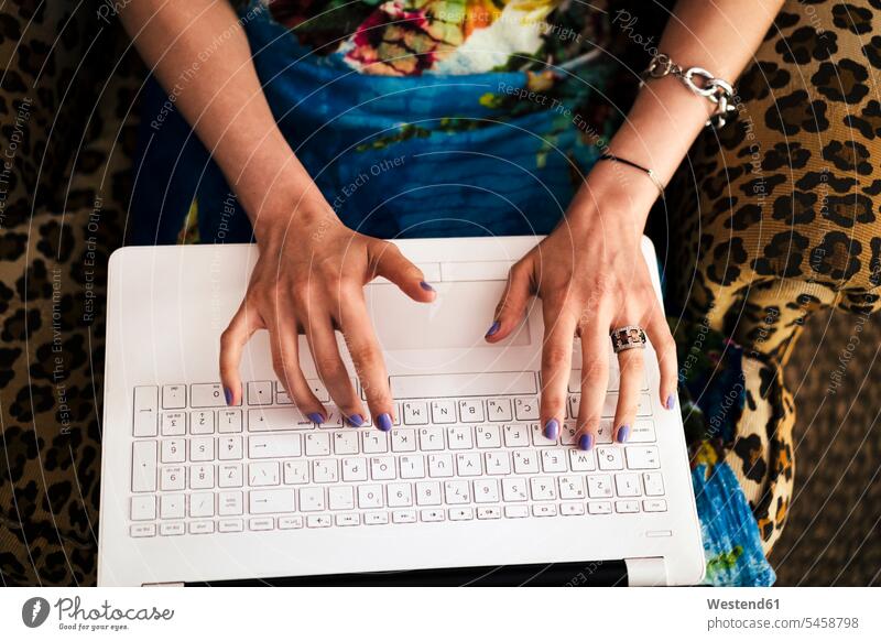 Nahaufnahme von Frauenhänden bei der Arbeit am Laptop zu Hause Farbaufnahme Farbe Farbfoto Farbphoto Innenaufnahme Innenaufnahmen innen drinnen Tag