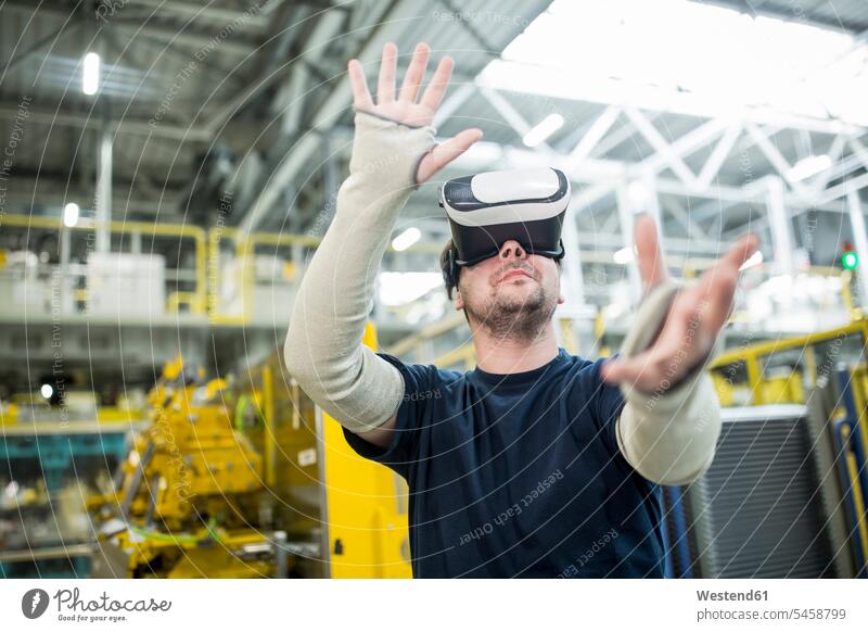Mann mit VR-Brille in moderner Fabrik Job Berufe Berufstätigkeit Beschäftigung Jobs Arbeiter Techniken Technologie Anlagenbau Ingenieurwissenschaft Maschinenbau