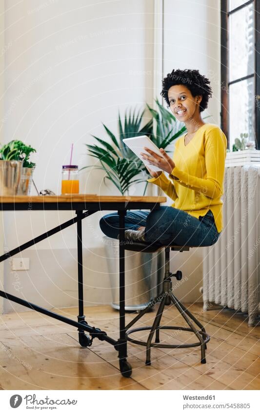 Junge Frau sitzt zu Hause und liest auf einem digitalen Tablet arbeiten junge Frau lernen studieren lesen Zuhause Erwachsener Mensch Computer Home Office
