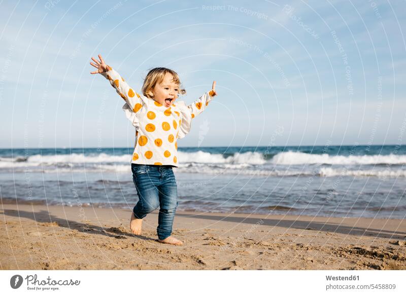 Glückliches kleines Mädchen läuft barfuß am Strand Vitalität Elan Schwung dynamisch Energie vital Meeresufer Hochgefühl Heiterkeit heiter Glücksgefühl