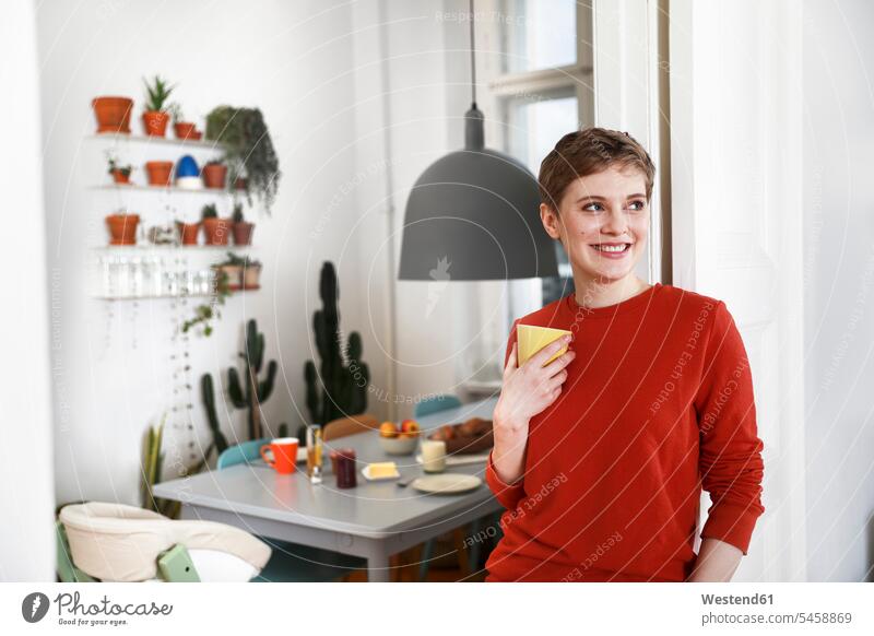 Frau steht in ihrem gemütlichen Haus und trinkt Kaffee glücklich Glück glücklich sein glücklichsein trinken Komfortabel Gemütlich Bequem Zuhause zu Hause daheim