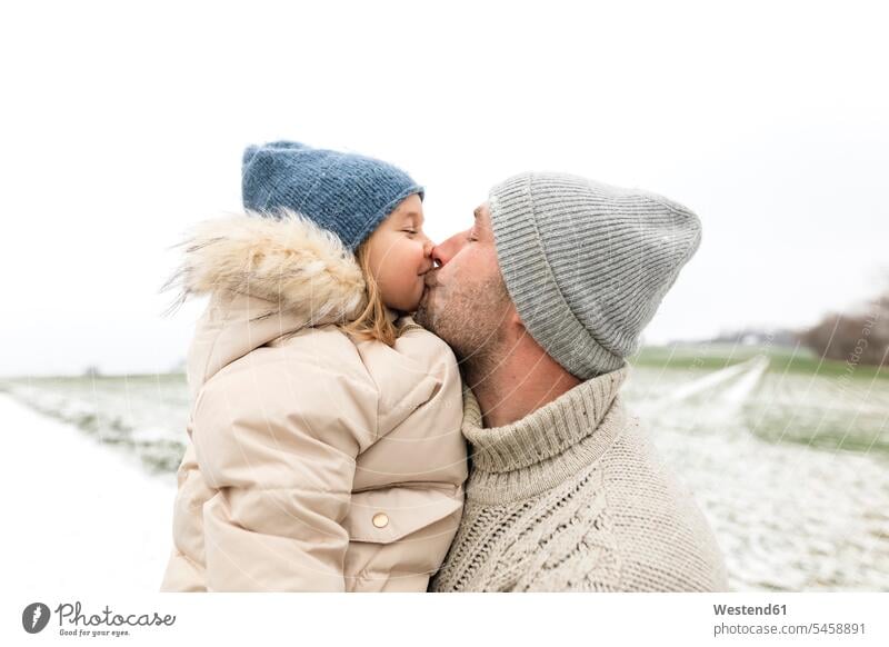 Vater küsst Tochter im Winter küssen Küsse Kuss Töchter winterlich Winterzeit Papas Väter Vati Vatis Papis Kind Kinder Familie Familien Mensch Menschen Leute