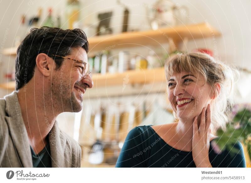 Glückliches Paar lächelt sich zu Hause in der Küche an Brillen freuen Frohsinn Fröhlichkeit Heiterkeit glücklich sein glücklichsein gefühlvoll Emotionen