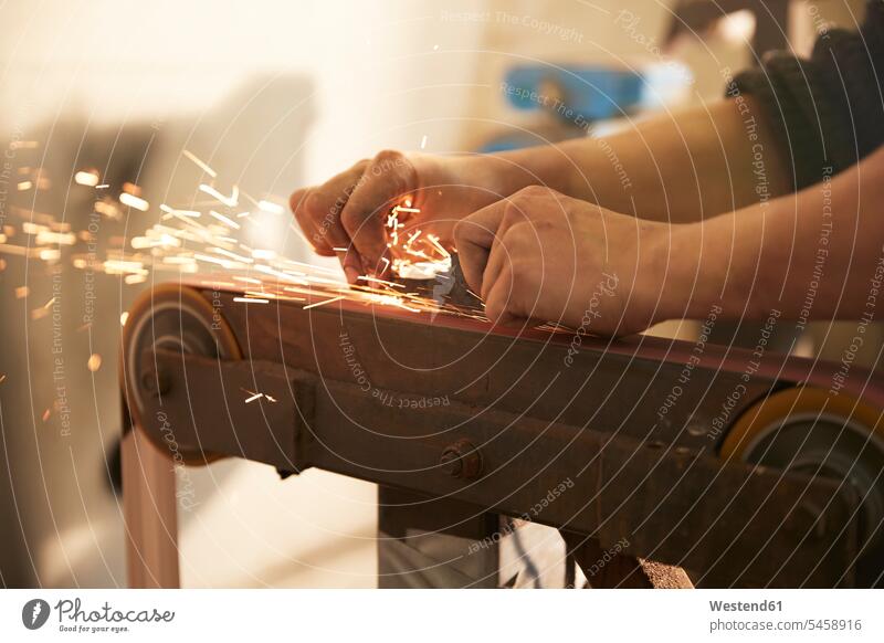 Mann beim Schleifen einer Klinge in einer Werkstatt Job Berufe Berufstätigkeit Beschäftigung Jobs Geräte Werkzeuge Arbeit Qualitaet Gewerbe industriell