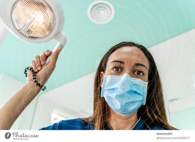 Arzt mit einstellbarem Licht bei der Arbeit in der Zahnarztpraxis Farbaufnahme Farbe Farbfoto Farbphoto Innenaufnahme Innenaufnahmen innen drinnen Spanien