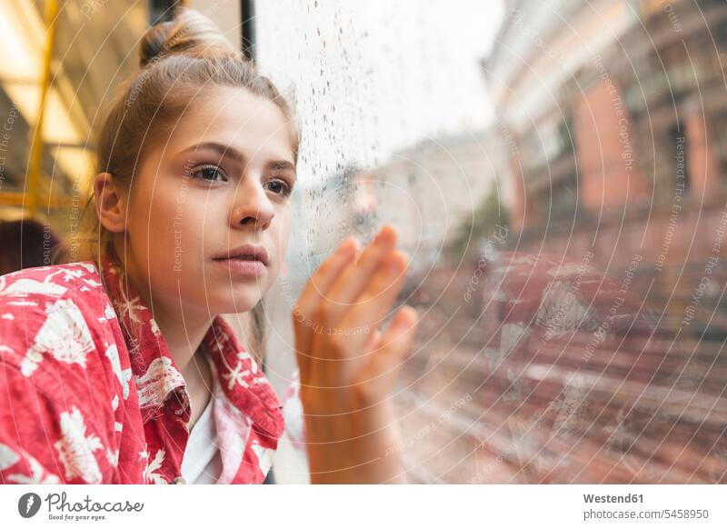 Junge Frau reist mit dem Zug und schaut aus dem Fenster Fensterscheiben Transport Transportwesen Bahnen Subway U-Bahnen Ubahn Ubahnen Underground Untergrundbahn
