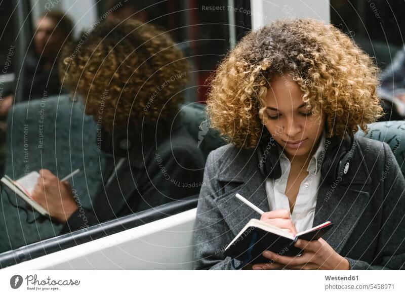 Frau macht Notizen in einer U-Bahn geschäftlich Geschäftsleben Geschäftswelt Geschäftsperson Geschäftspersonen Businessfrau Businessfrauen Businesswoman