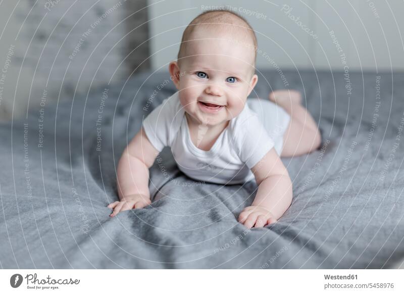 Porträt eines lachenden kleinen Jungen auf dem Bett liegend Portrait Porträts Portraits männliche Babys männliches Baby männliche Babies Betten liegt Kind