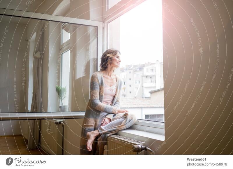Reife Frau schaut aus dem Fenster weiblich Frauen schauen sehend Tag am Tag Tageslichtaufnahme tagsueber Tagesaufnahmen Tageslichtaufnahmen tagsüber Erwachsener