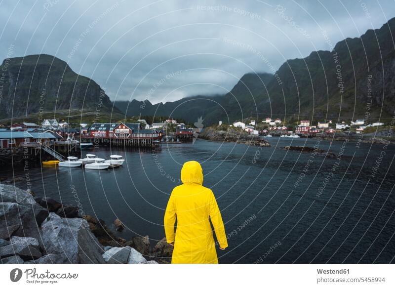 Norwegen, Lofoten, Rückansicht eines Mannes, der in einem Fischerdorf an der Küste steht stehen stehend Kueste Kuesten Küsten Männer männlich Dorf Dörfer