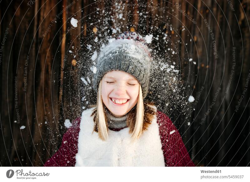Schnee fällt auf glückliches Mädchen mit Wollmütze Mützen Jahreszeiten winterlich Winterzeit freuen Frohsinn Fröhlichkeit Heiterkeit Glück glücklich sein