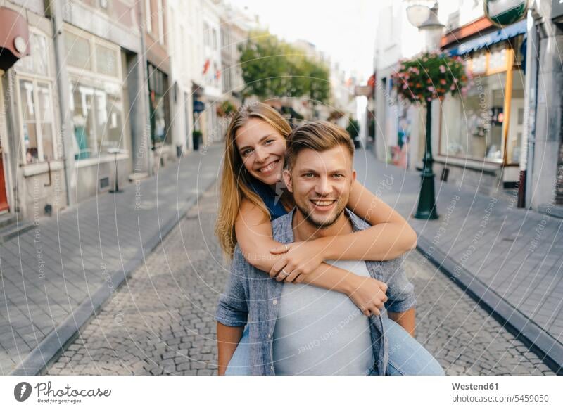 Niederlande, Maastricht, Porträt eines glücklichen jungen Paares in der Stadt Pärchen Partnerschaft Portrait Porträts Portraits Glück glücklich sein