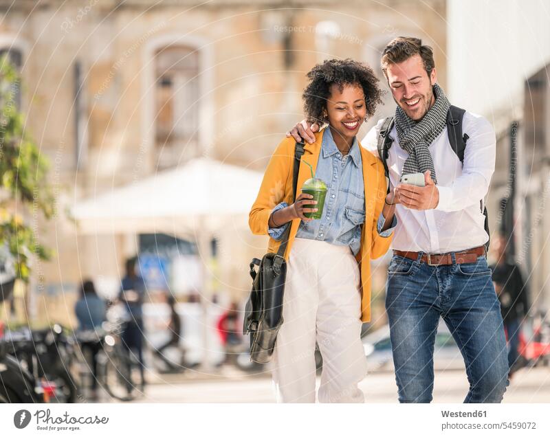 Glückliches junges Paar mit Smartphone in der Stadt Leute Menschen People Person Personen Europäisch Kaukasier kaukasisch 2 2 Menschen 2 Personen zwei