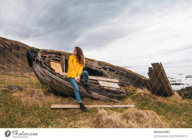 Island, Frau in Bootswrack an der Küste Wrack Wracks Boote Kueste Kuesten Küsten weiblich Frauen Republik Island Wasserfahrzeuge Erwachsener erwachsen Mensch