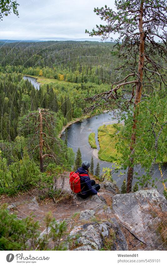 Finnland, Oulanka National Park, Frau mit Rucksack sitzt in unberührter Natur weiblich Frauen sitzen sitzend Erwachsener erwachsen Mensch Menschen Leute People