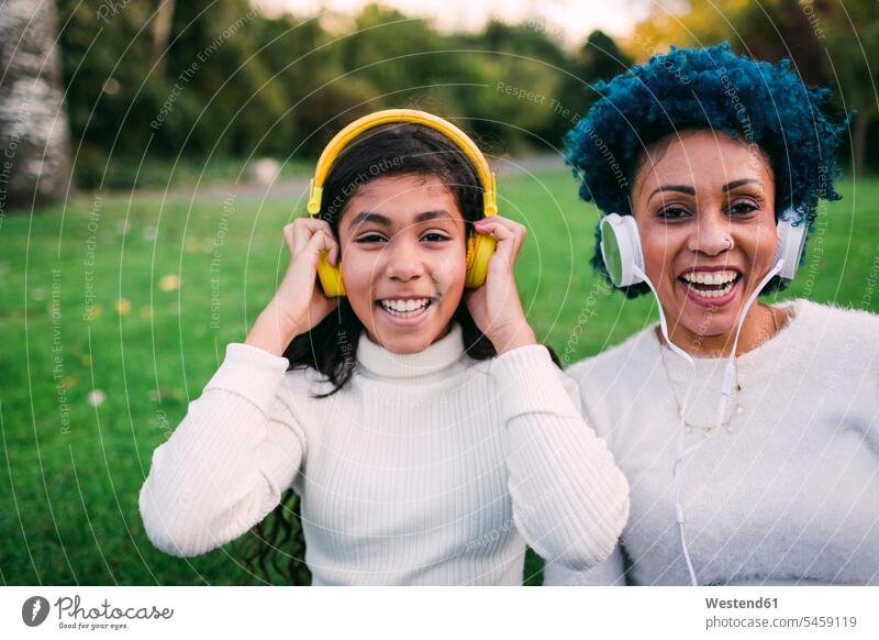Glückliche Mutter und Tochter hören im Park Musik über Kopfhörer Farbaufnahme Farbe Farbfoto Farbphoto Portugal Freizeitbeschäftigung Muße Zeit Zeit haben