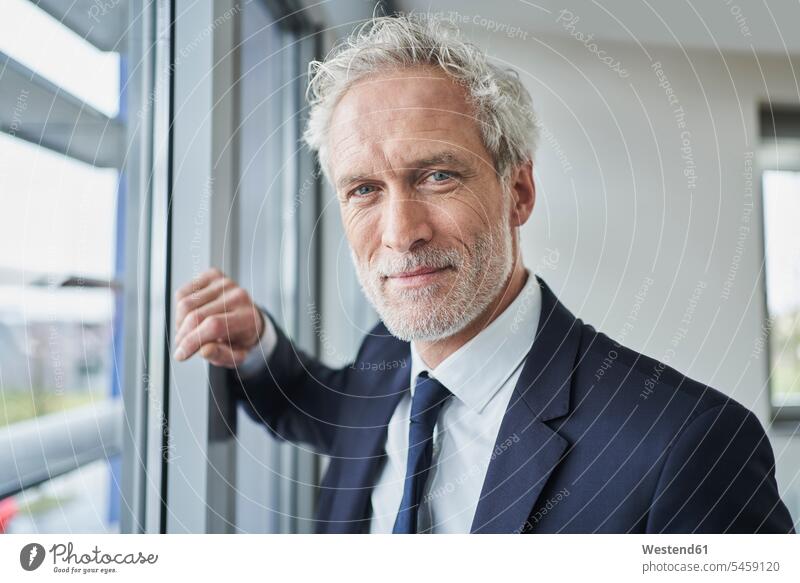 Porträt eines selbstbewussten Geschäftsmannes am Fenster Job Berufe Berufstätigkeit Beschäftigung Jobs geschäftlich Geschäftsleben Geschäftswelt Geschäftsperson