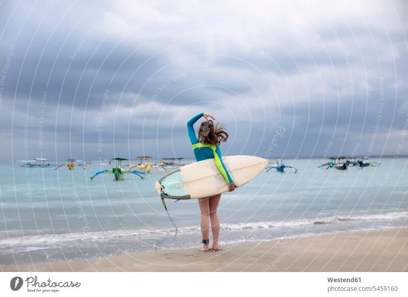 Indonesien, Bali, junge Frau mit Surfbrett Surfbretter surfboard surfboards weiblich Frauen Freizeit Muße stehen stehend steht Surferin Wellenreiterinnen