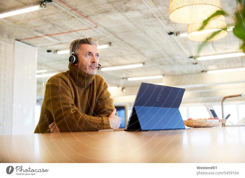 Nachdenklich Geschäftsmann mit Headset und digitale Tablette weg schauen, während im Büro sitzen Farbaufnahme Farbe Farbfoto Farbphoto Innenaufnahme