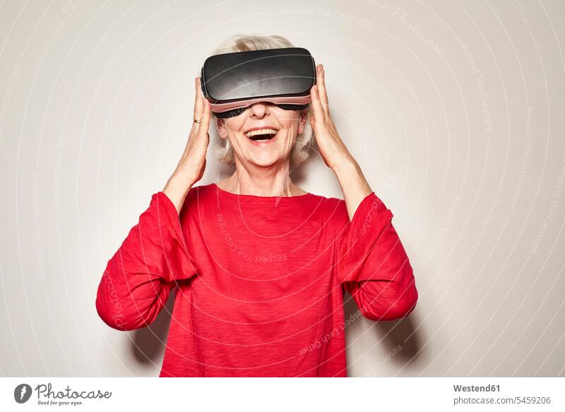 Porträt einer lachenden reifen Frau mit Virtual-Reality-Brille freuen Glück glücklich sein glücklichsein Farben Farbtoene Farbton Farbtöne rote roter rotes